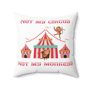 May include: White throw pillow with the text "NOT MY CIRCUS NOT MY MONKEYS" in red. The pillow features a cartoon illustration of a red and white striped circus tent with two monkeys.