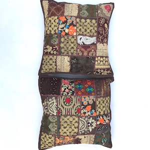 Könnte beinhalten: Zwei braune Patchwork-Kissenbezüge mit bunten Stickereien und Verzierungen. Die Kissenbezüge bestehen aus verschiedenen Stoffen und haben eine Vielzahl von Mustern.