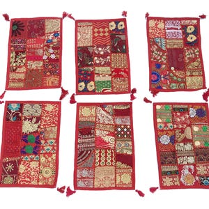 Könnte beinhalten: Sechs rote Patchwork-Kissenbezüge mit bunten Stickereien und Quasten. Die Bezüge sind aus verschiedenen Stoffen gefertigt und weisen eine Vielzahl von Mustern und Designs auf.