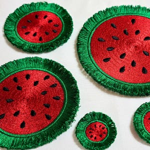 May include: Four embroidered watermelon patches with green fringe. The patches are different sizes and are arranged on a white background.