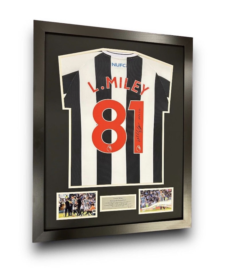 May include: A framed black and white soccer jersey with the number 81 and the name "L. Miley" on the back. The jersey is signed by the player. The frame includes three smaller photos of the player in action.