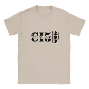 以下が含まれることがあります： ベージュ色のTシャツ。黒色のグラフィックデザインが特徴です。「THE PROFESSIONALS」の文字と数字の「5」、フィルムストリップのシルエットが含まれています。クルーネックと半袖のデザインです。