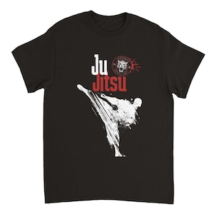 May include: Black t-shirt featuring a white silhouette of a person performing a martial arts kick. The text "Ju Jitsu" is in red and white, with a red circle containing a tiger graphic and the words "Japanese Gentle Art" above it.