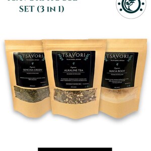 May include: Three Tsavori House tea pouches are displayed. The brown pouches have black labels with clear windows, showcasing the tea. The labels read "Sencha Green", "Alkaline Tea", and "Maca Root". The image also includes the text "Organic" and "View Product".