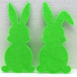 May include: Two green felt bunny shapes, perfect for crafting or decorating.