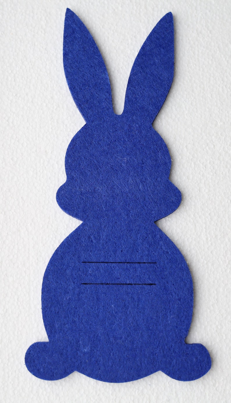 May include: A blue felt bunny cutout with two lines drawn on the body.