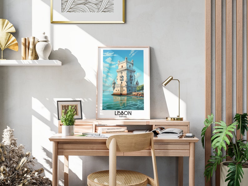 Op de afbeelding: Een ingelijste poster met een kleurrijke illustratie van een toren in het water. De poster heeft de tekst "LISBON, PORTUGAL" onderaan.