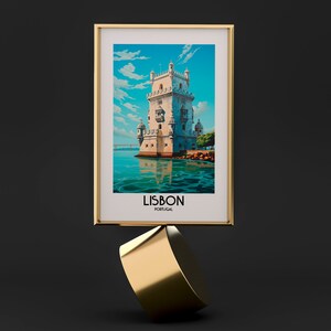 Op de afbeelding: Een ingelijste print van een witte toren met een blauwe lucht en water op de achtergrond. De tekst "LISBON PORTUGAL" staat onder de afbeelding.