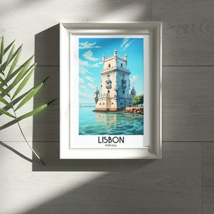 Op de afbeelding: Een witte ingelijste print van een aquarel van een toren op het water in Lissabon, Portugal. De tekst "LISBON" en "PORTUGAL" staat onder de afbeelding.