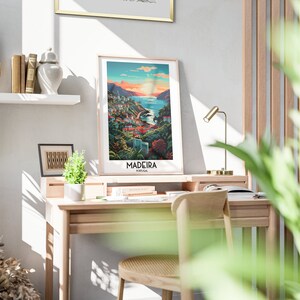 May include: A framed poster with a colorful illustration of a coastal town with a body of water in the background. The poster has the text "Madeira, Portugal" at the bottom.