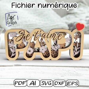 Op de afbeelding: Houten "PAPI" bord met de woorden "Je t'aime" uitgesneden, gevuld met bloemmotieven in bruin- en roze tinten. Een rood hart is bevestigd aan de letter "I". Het bord is een digitaal bestand, zoals aangegeven door de tekst bovenaan en onderaan.