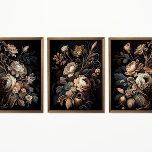 May include: Set of three framed floral art prints. Each print features a detailed illustration of a bouquet of flowers in shades of cream, brown, and peach against a black background. The frames are a warm brown color.