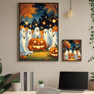 Peut inclure: Deux impressions d'art d'Halloween encadrées. La plus grande représente des fantômes de dessins animés autour d'une citrouille sculptée dans un cadre forestier aux teintes orange et bleu. La plus petite impression est un miroir de la plus grande. Les deux sont encadrées en noir.