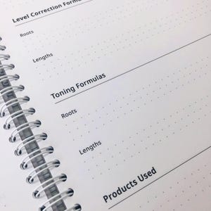 May include: A white spiral-bound notebook page with a dot grid pattern. The page features printed black text including Level Correction Formulas, Roots, Lengths, Toning Formulas, Roots, Lengths, and Products Used, organised with horizontal lines.