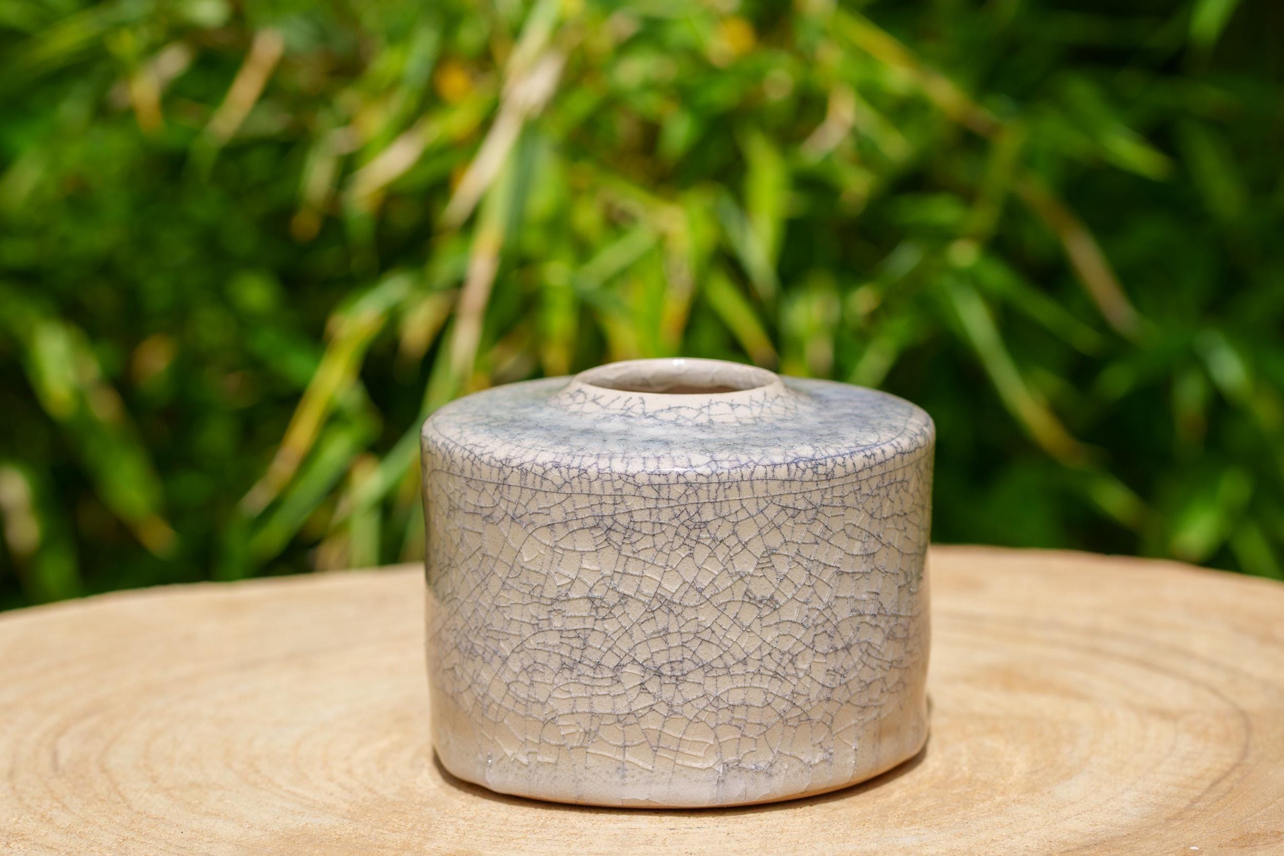 ベージュと黒の炻器の花瓶。白と黒のひび割れた陶器の鉢。手作りの楽焼