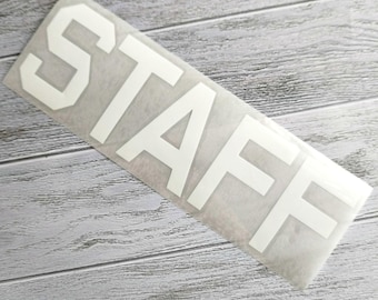 May include: White vinyl sticker with the word "STAFF" in large, block letters.