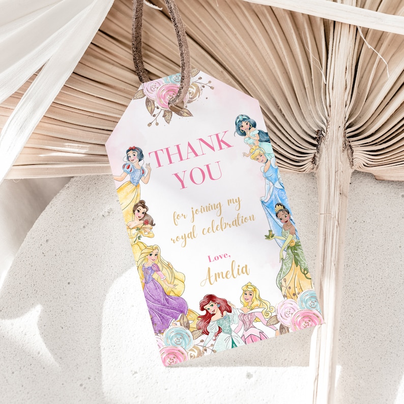 May include: Pink and white thank you tag with a floral design and images of Disney princesses. The text reads "Thank You for joining my royal celebration. Love, Amelia."