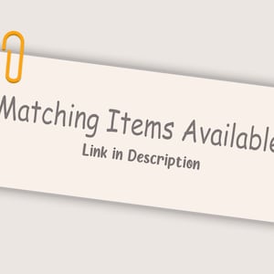 May include: A light beige rectangular sticky note with the text "Matching Items Available" and "Link in Description" in gray. An orange paper clip secures the note to the top left corner. The background is a light beige color.