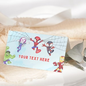 May include: A folded card with illustrations of Spider-Man characters and the Hulk on a light blue watercolour background. The text "YOUR TEXT HERE" is printed in red. The card is suitable for a party or event.