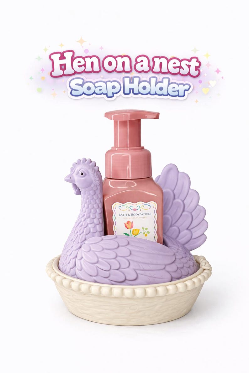 以下が含まれることがあります： ラベンダー色の鶏の形をした石鹸ホルダーとピンクのポンプボトルを備えた装飾的な石鹸ディスペンサー。ホルダーは巣のようにデザインされています。「Hen on a nest Soap Holder」のテキストが上に表示されています。