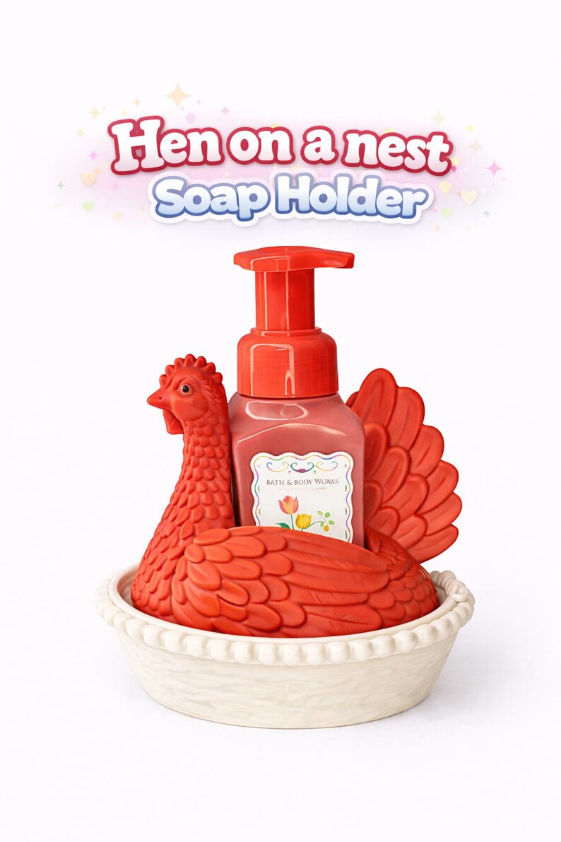 以下が含まれることがあります： 赤い鶏の形をした石鹸ホルダーと、それに合う石鹸ディスペンサー。鶏は白いパイ型の皿の中にあります。「Hen on a nest Soap Holder」というテキストが上に表示されています。