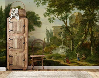 Op de afbeelding: Een vintage-stijl behangmuur die een klassiek landschap met een standbeeld, bomen en een stenen gebouw afbeeldt. De muurschildering wordt weergegeven in een kamer met een houten kast en een stoel.