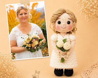 May include: A handmade crochet doll with light brown yarn hair, wearing a white dress and holding a small bouquet of white crocheted flowers. The doll features black safety eyes and pink cheeks. Beside it is a photograph of a person in a white dress.