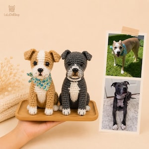 May include: Two handmade crochet dog figurines sitting on a wooden tray. One dog is tan and white with a blue floral bandana, and the other is dark gray and white. Next to the tray are two photographs of real dogs matching the crochet designs.