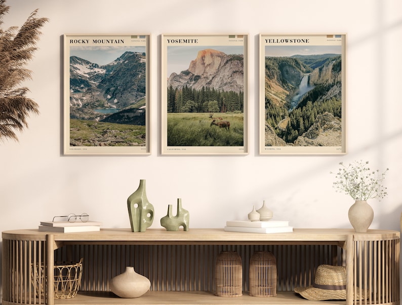 K&ouml;nnte beinhalten: Drei Vintage-Reiseposter mit malerischen Ansichten von Nationalparks. Die Poster sind in hellem Holz gerahmt und an einer wei&szlig;en Wand aufgeh&auml;ngt. Die Poster zeigen folgenden Text: "Rocky Mountain", "Yosemite" und "Yellowstone".