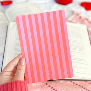 May include: A rectangular card featuring a vertical striped pattern in alternating shades of bright pink and coral orange. The card has rounded corners and a smooth, flat surface, presented as a solid, opaque object with a consistent colour scheme.