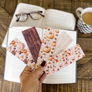 May include: Set of five fall-themed bookmarks. The bookmarks feature a variety of designs, including pumpkins, leaves, and floral patterns. The bookmarks are printed on a white background.