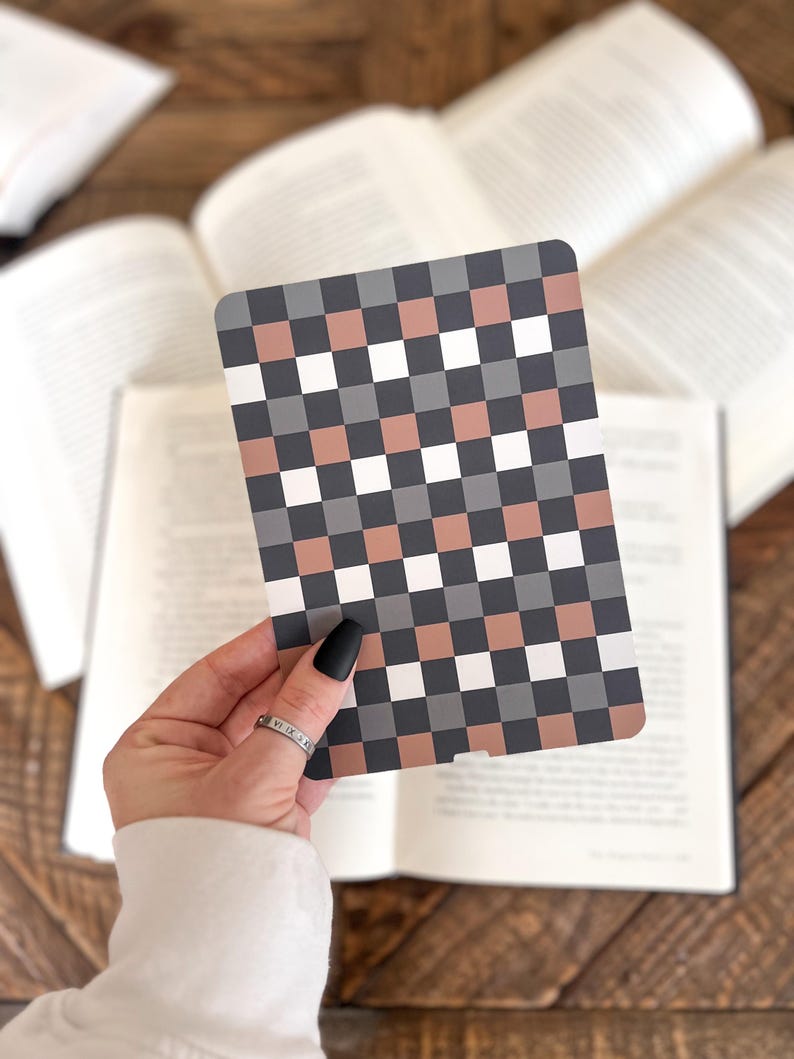 May include: A rectangular card featuring a repeating checkered pattern in alternating shades of white, dark gray, and muted terracotta. The card has rounded corners and a smooth, flat surface, displaying a consistent grid design across its entire front.