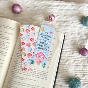 May include: Two colorful bookmarks with illustrations of teacups and a house. The text on the bookmarks reads "It's beginning to smell like winter small town romance".