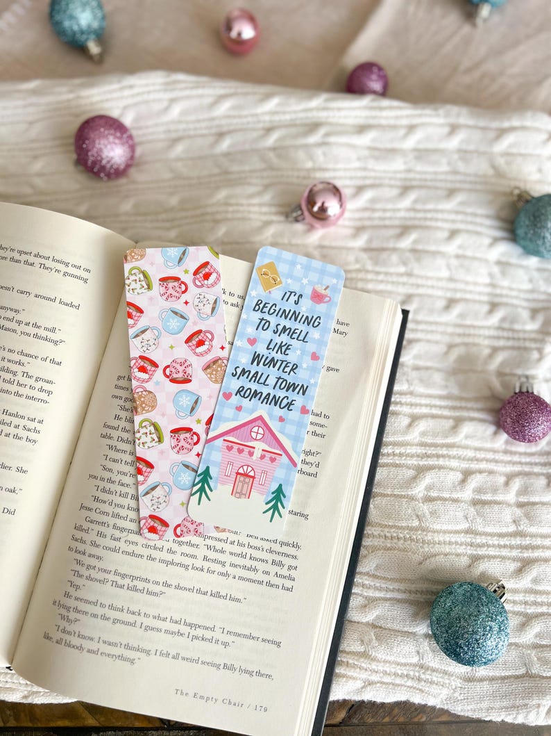 May include: Two colorful bookmarks with illustrations of teacups and a house. The text on the bookmarks reads "It's beginning to smell like winter small town romance".