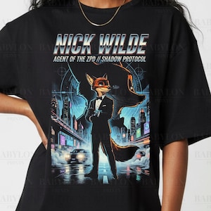 May include: Black t-shirt featuring a graphic of Nick Wilde, an anthropomorphic fox in a suit, from Zootopia. The design includes the text "NICK WILDE AGENT OF THE ZPD // SHADOW PROTOCOL" and a cityscape background. The shirt is labeled "Comfort Colors Black."
