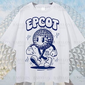 Pu&ograve; includere: T-shirt bianca oversize con un personaggio blu a fumetti con la scritta "EPCOT". Il personaggio &egrave; un globo sorridente con braccia e gambe, e il testo "Est. 1982" &egrave; sotto. La maglietta ha anche il testo "Oversized Tee!" in basso.
