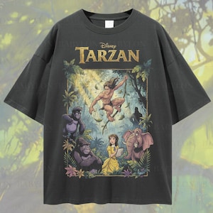 May include: Dark gray oversized t-shirt featuring a colorful Disney Tarzan graphic. The graphic includes Tarzan, Jane, gorillas, and an elephant. Text on the shirt reads "Disney Tarzan". Additional text includes "Oversized Pepper" and "Oversized Tee!"