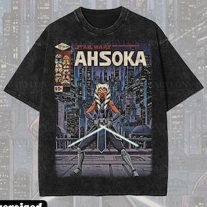 May include: Black oversized premium tee featuring a Star Wars Ahsoka graphic. The design includes the text "STAR WARS AHSOKA" and an illustration of the character with lightsabers. The shirt has a vintage wash and the text "Premium Wash: Black".