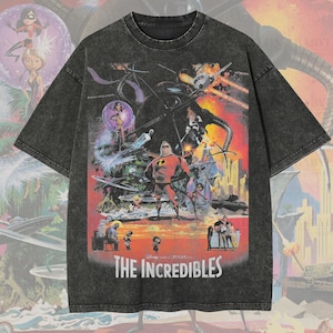May include: A dark gray, oversized t-shirt featuring a colorful graphic from "The Incredibles" movie. The design includes characters and the film's title. The shirt has the text "Premium Wash: Pepper" and "Oversized Premium Tee!"