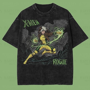 May include: Black oversized premium tee with a Rogue graphic from X-Men. The design includes the text "X-MEN" and "ROGUE" in green. The character is shown in a yellow and green costume, with energy effects.