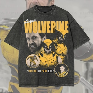Può includere: Una t-shirt oversize grigio antracite con una stampa grafica del personaggio Wolverine. Il design include il testo Logan, Wolverine e Trust me, kid, I'm no hero, insieme a diverse illustrazioni del personaggio in giallo e nero.