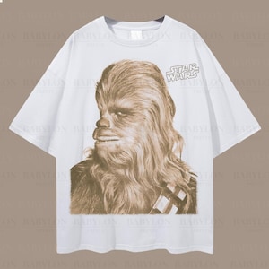 May include: White oversized t-shirt with a sepia-toned Chewbacca image from Star Wars. The Star Wars logo is on the upper right. Text on the shirt reads "Oversized White" and "Oversized Tee!"