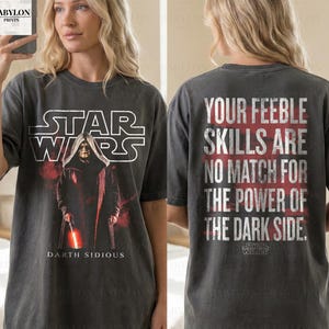 May include: Dark grey t-shirt with a Star Wars graphic featuring Darth Sidious, the text "STAR WARS" and "DARTH SIDIOUS". The back of the shirt has the text "YOUR FEEBLE SKILLS ARE NO MATCH FOR THE POWER OF THE DARK SIDE."