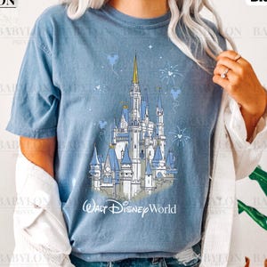 May include: A blue t-shirt with a white outline drawing of Cinderella's castle and the text "Walt Disney World".