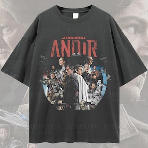 以下が含まれることがあります： スター・ウォーズ・アンドールのキャストのグラフィックプリントが施された、黒色のオーバーサイズTシャツ。シャツには「スター・ウォーズ・アンドール」の文字が赤色でプリントされています。
