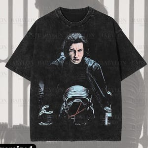 May include: Black oversized premium tee with a graphic of a science fiction character. The image includes the text "Premium Wash: Black", "Oversized Premium Tee!" and "Original Artist of This Design".