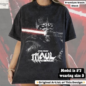 May include: Black t-shirt featuring a graphic of Darth Maul from Star Wars with a red lightsaber. The text "STAR WARS MAUL SHADOW LORD" is below the image. The shirt is a premium wash and the model is 5'7 wearing size S.