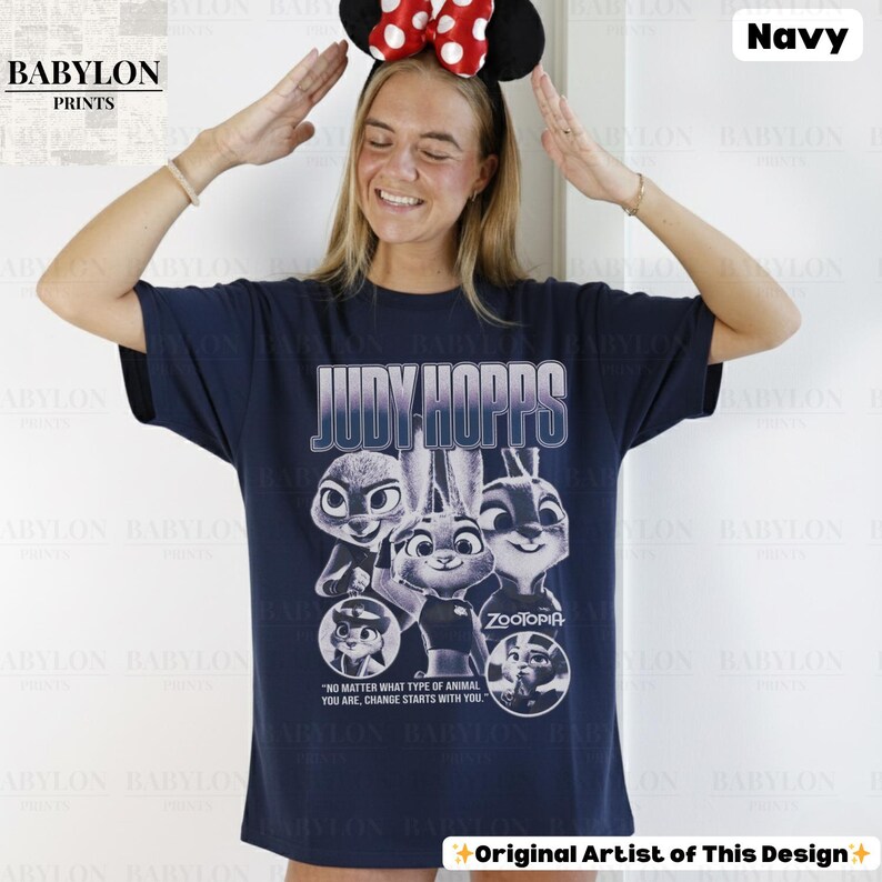 May include: Navy blue t-shirt featuring the text "JUDY HOPPS" above a graphic of characters from the movie Zootopia. The shirt also includes the quote "NO MATTER WHAT TYPE OF ANIMAL YOU ARE, CHANGE STARTS WITH YOU."