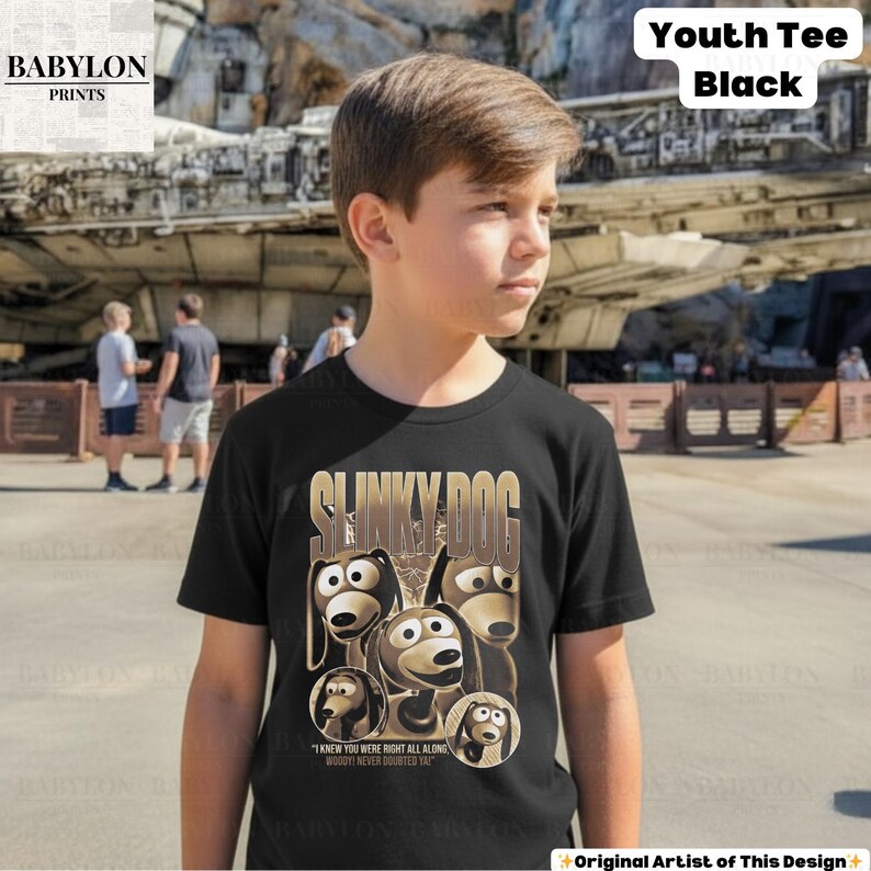 May include: Black youth tee featuring a Slinky Dog graphic with the text "I knew you were right all along, Woody never doubted ya". The shirt also has the text "Youth Tee Black" in the upper right corner.
