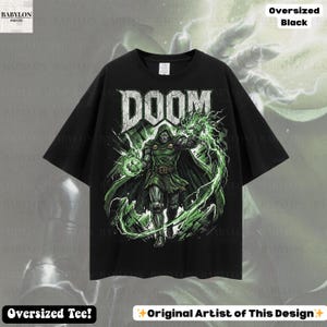 May include: Black oversized t-shirt featuring a graphic of a character with the word "DOOM" in white block letters. The character is in a green and black outfit with green energy effects. The shirt has the text "Oversized Black" and "Oversized Tee!"